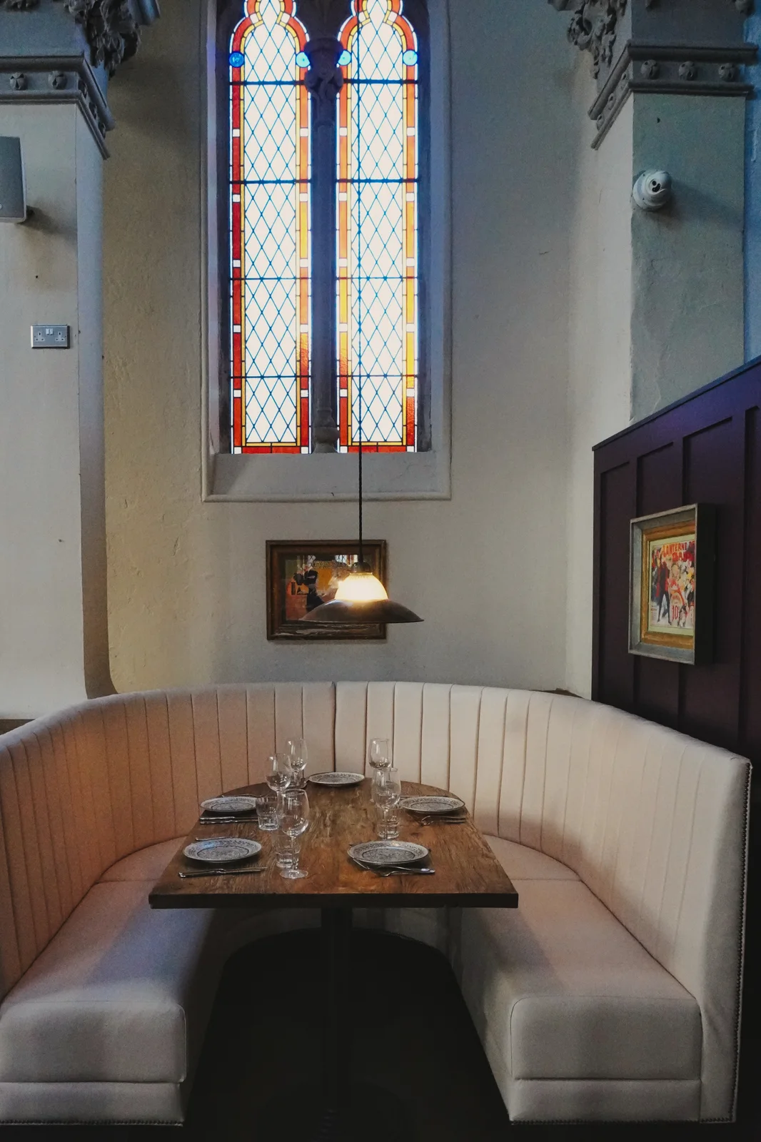 Cream dining booths beneath tall church windows