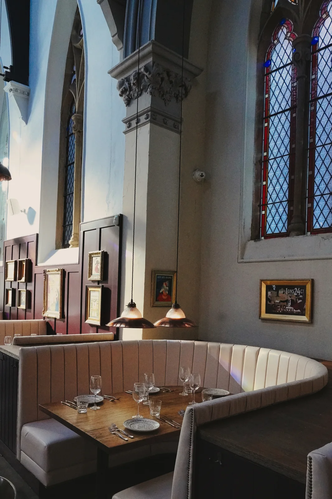 Cream dining booths beneath tall church windows