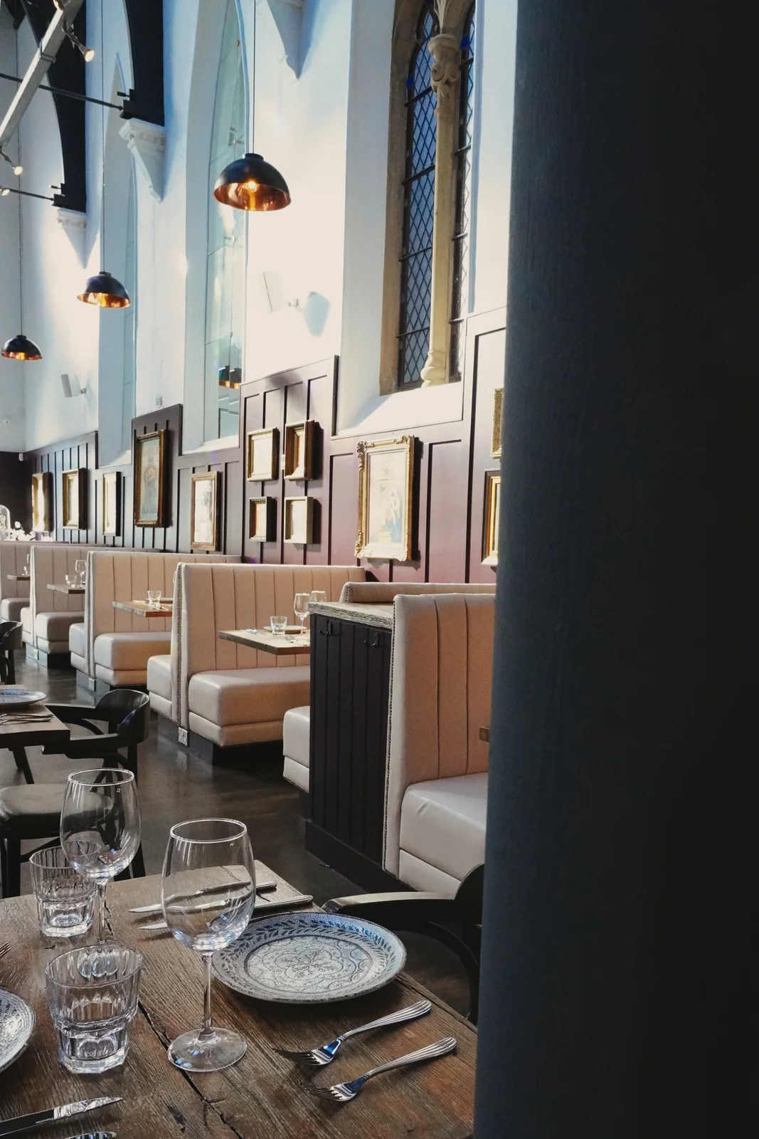 Cream dining booths beneath tall church windows