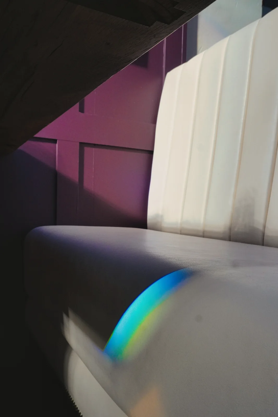 Coloured sunlight falling across a cream upholstered booth
