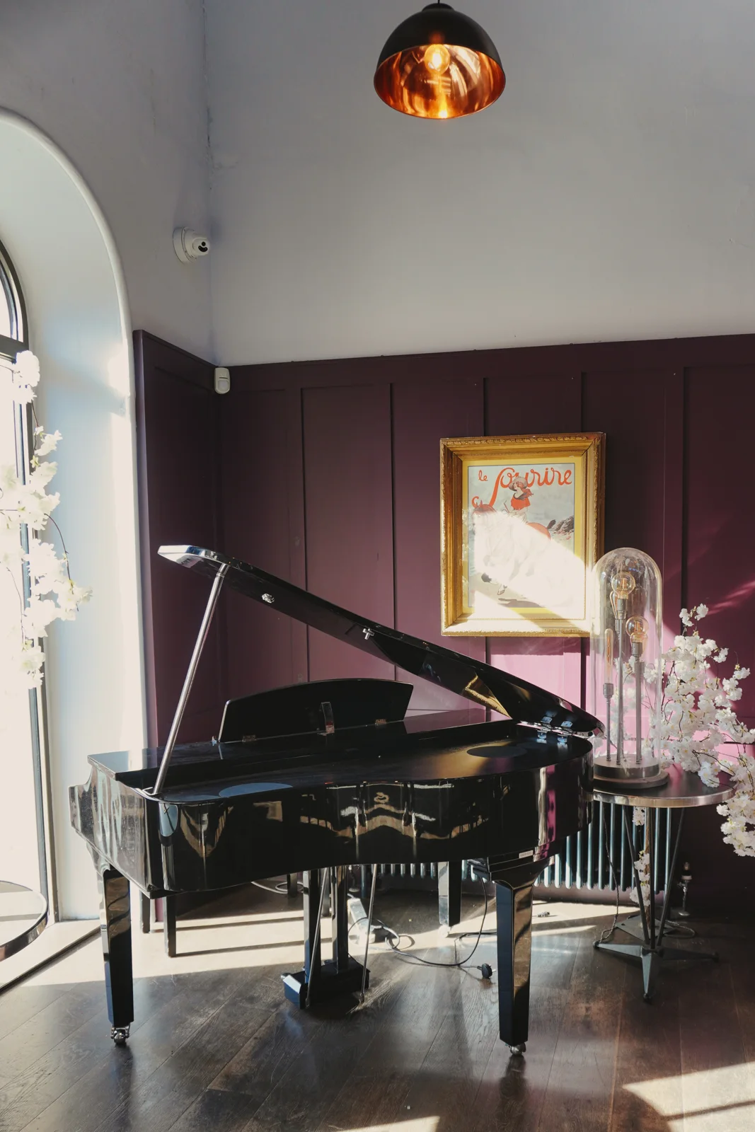 A grand piano beside flowers in the dining room
