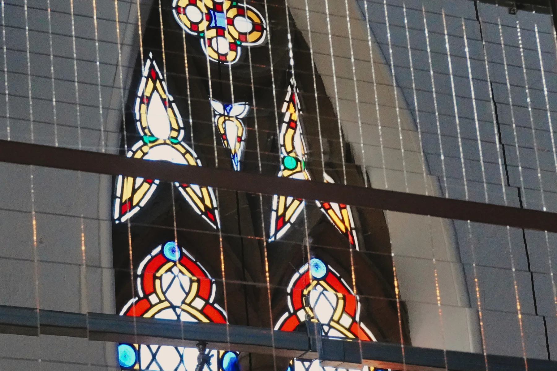 Stained-glass details seen through the gallery railing