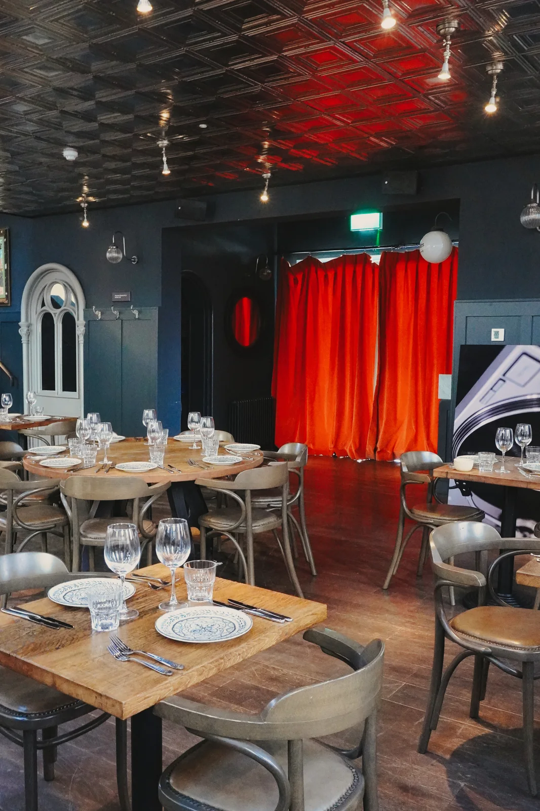 A round dining table beside red curtains