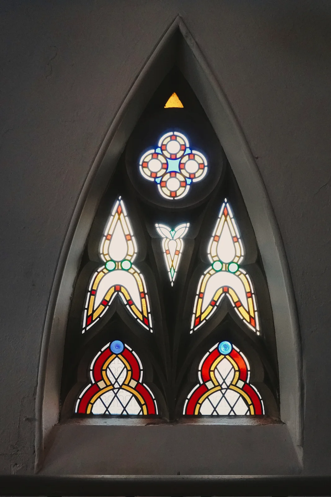 A pointed stained-glass church window
