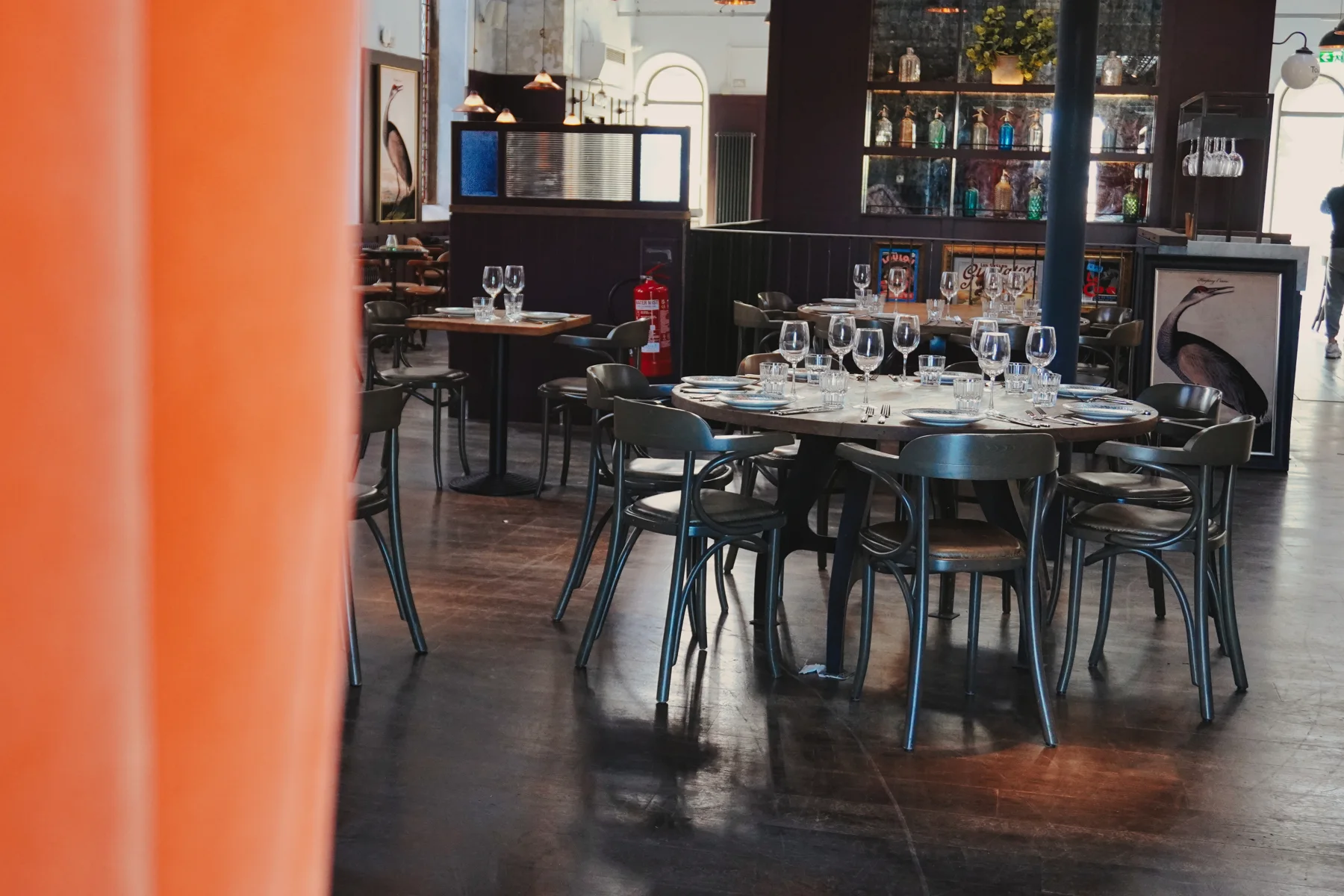 A glimpse into the dining room through warm orange curtains