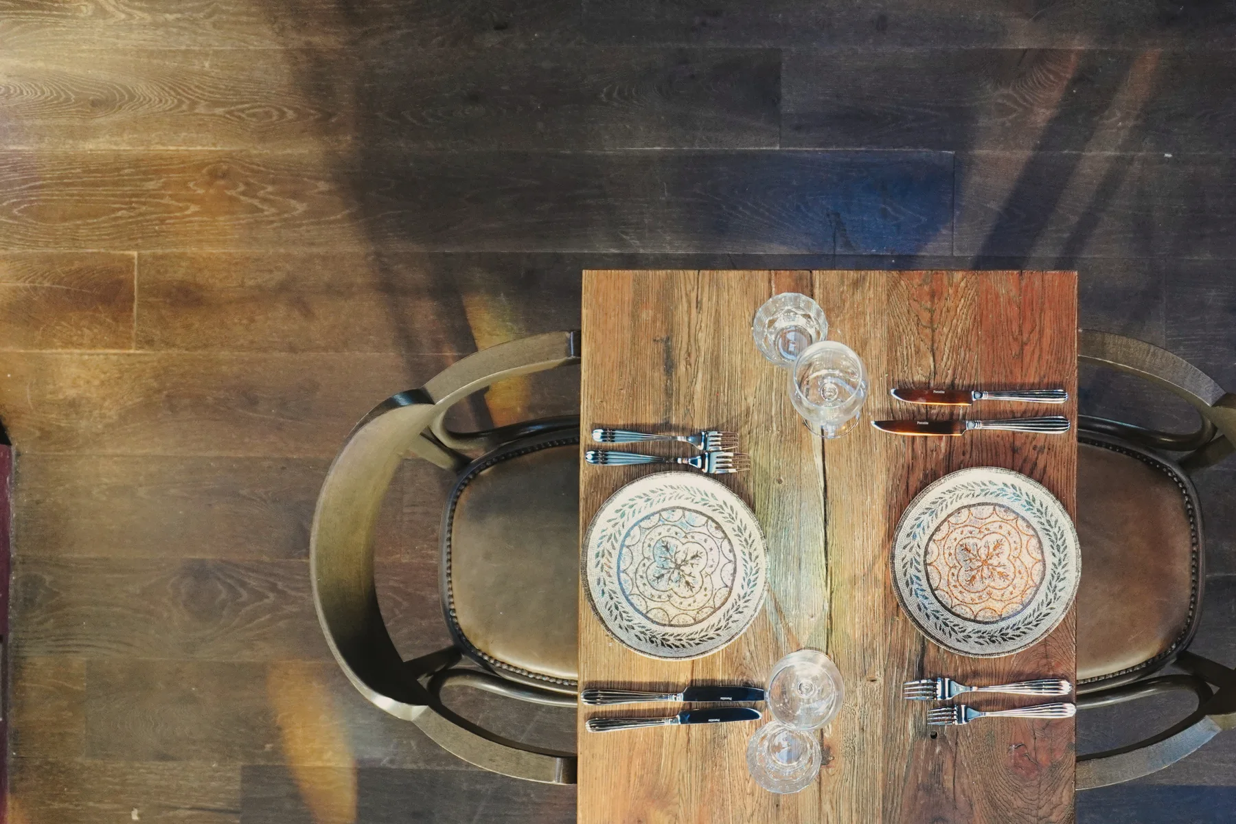 Patterned crockery arranged on a wooden dining table
