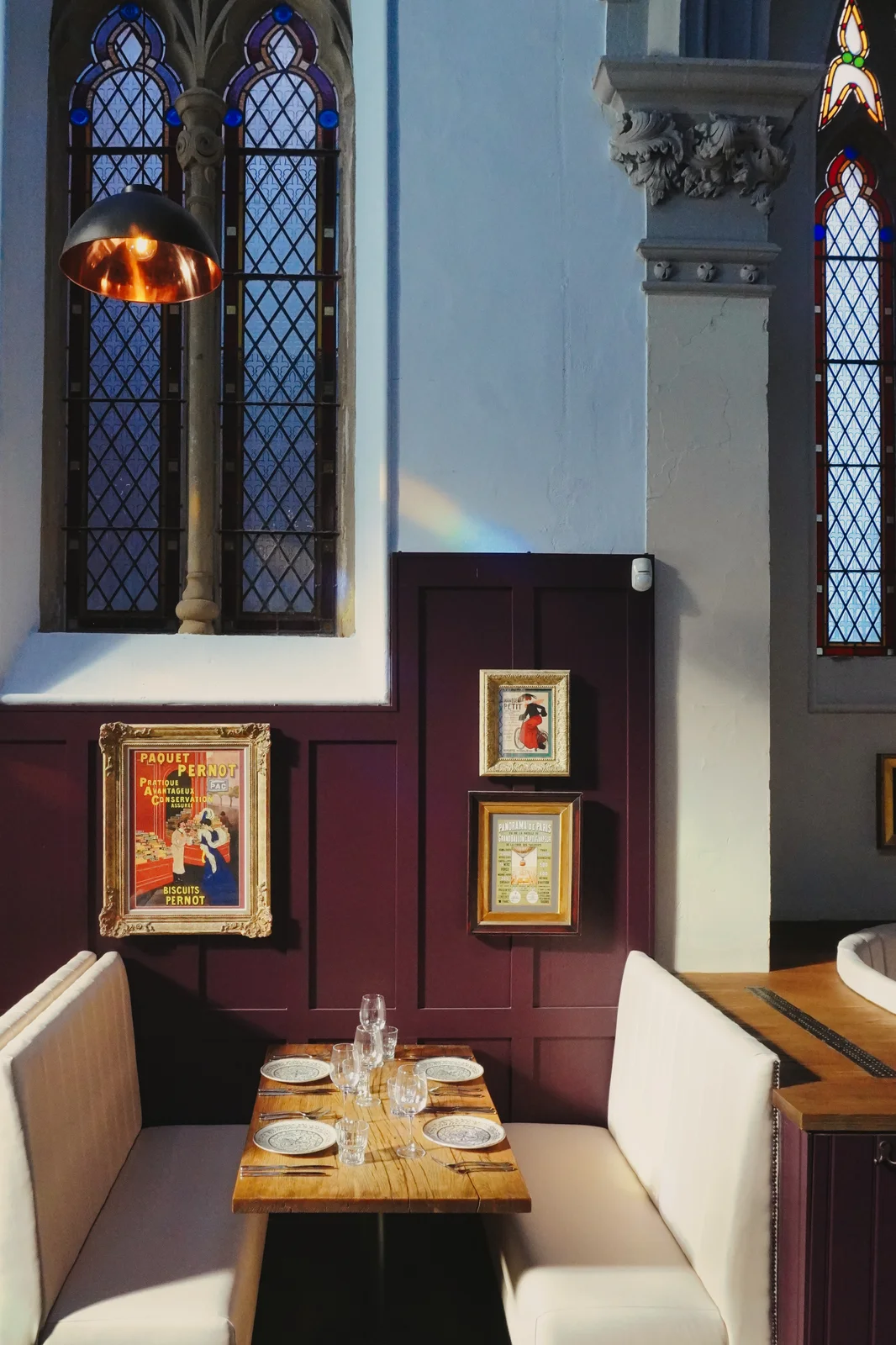 An intimate dining booth beneath stained glass