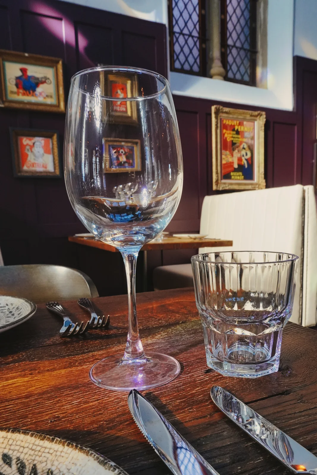 Glassware on a table beside framed artwork