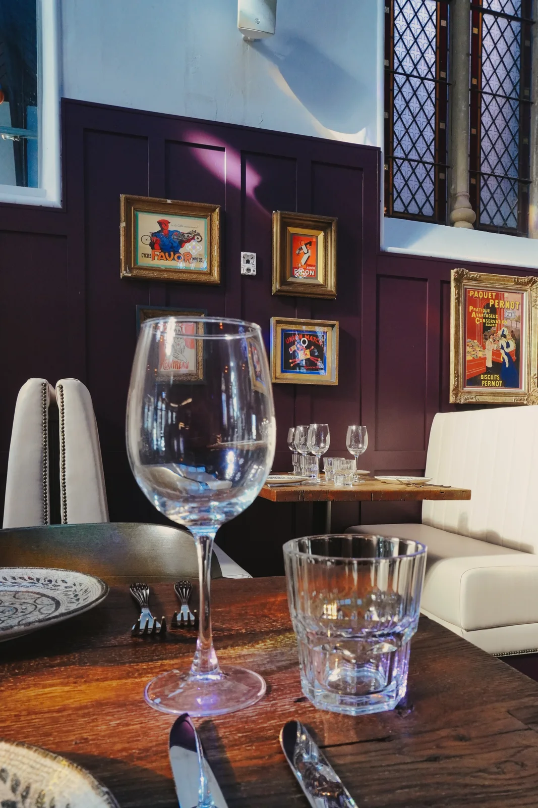 Glassware on a table beside framed artwork