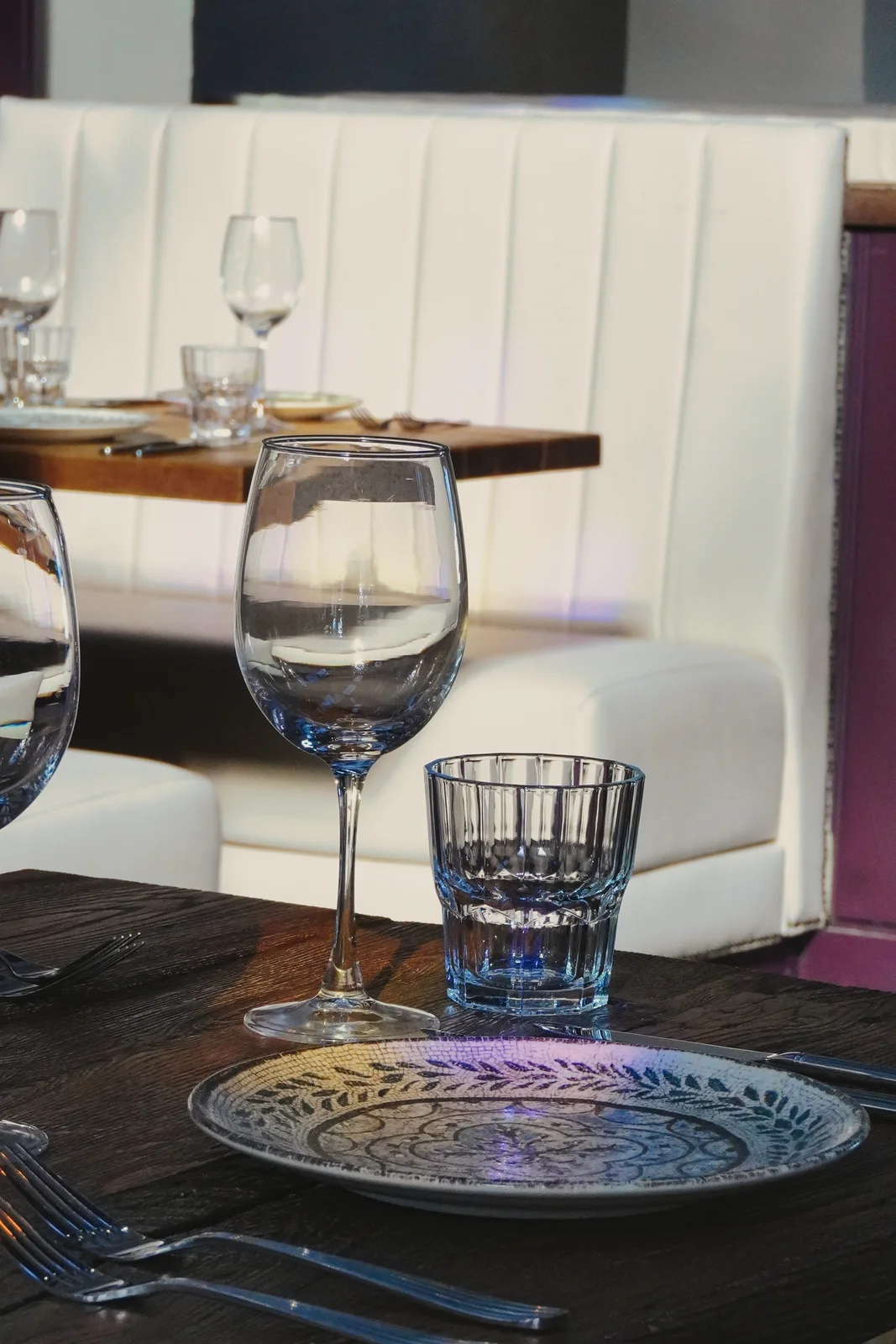 Glassware and place settings beside cream seating